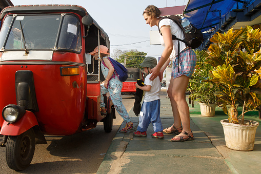 Family on vacation, mother and kids getting in a tuk-tuk, having fun. Travelling with children, backpacking, family time, active lifestyle concept.